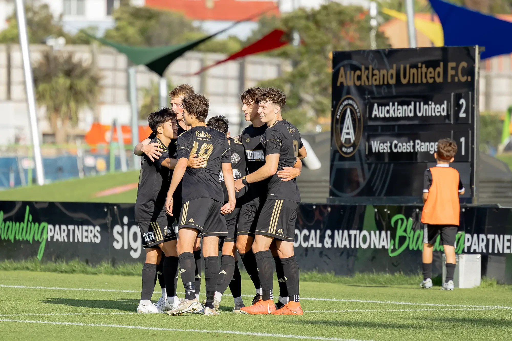 Aukland United Football Club players celebrate goal.