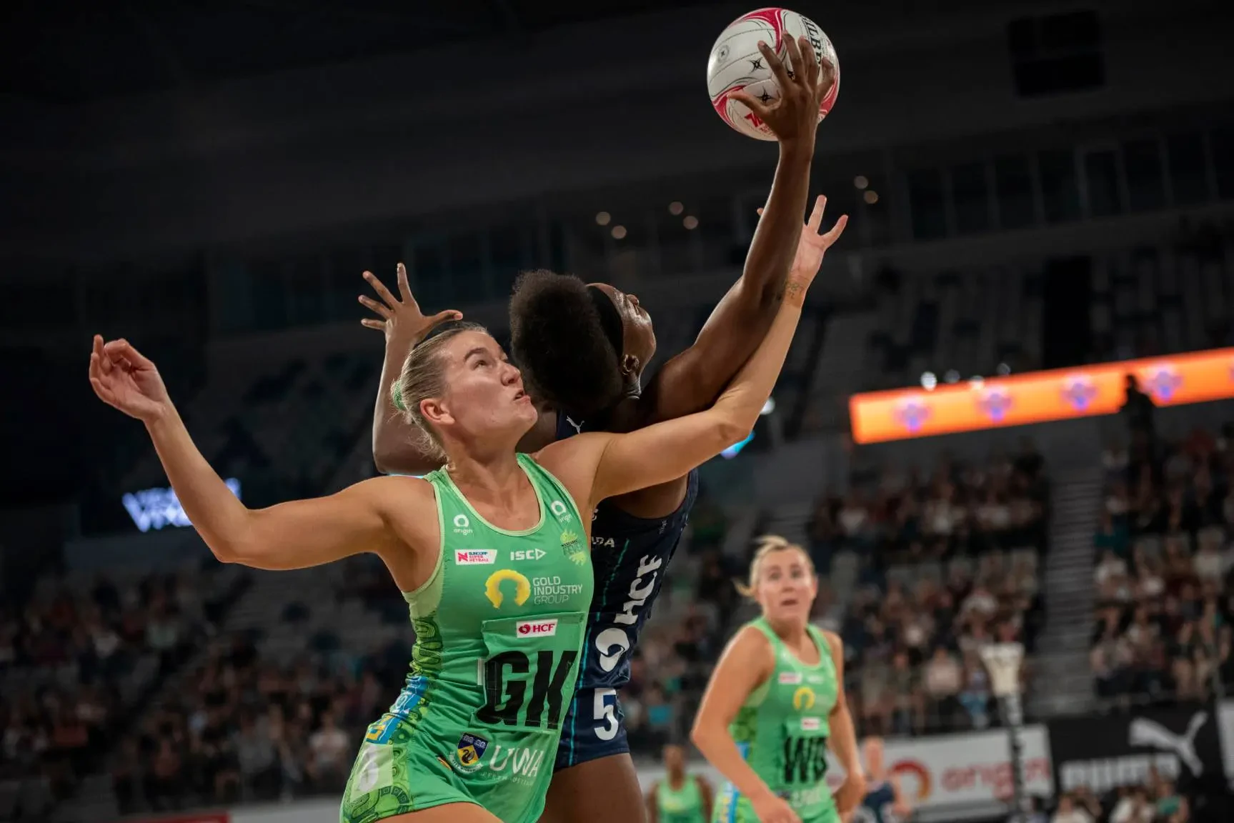 Photo of West Coast Fever Netball Club player competing for the ball.